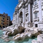 The Trevi Fountain in daylight, with its rocks and statues above the water
