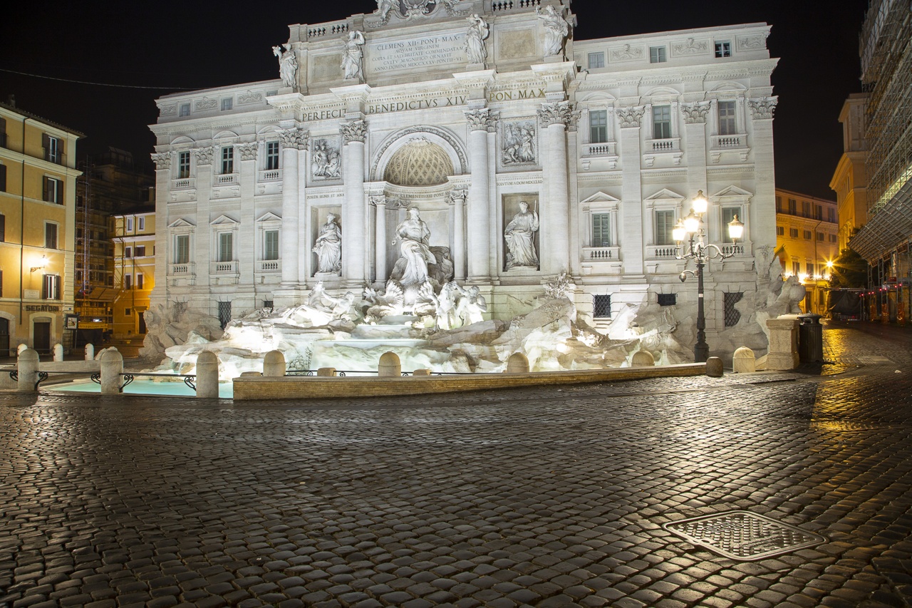 Das Bild zeigt den beleuchteten Trevi-Brunnen bei Nacht.
