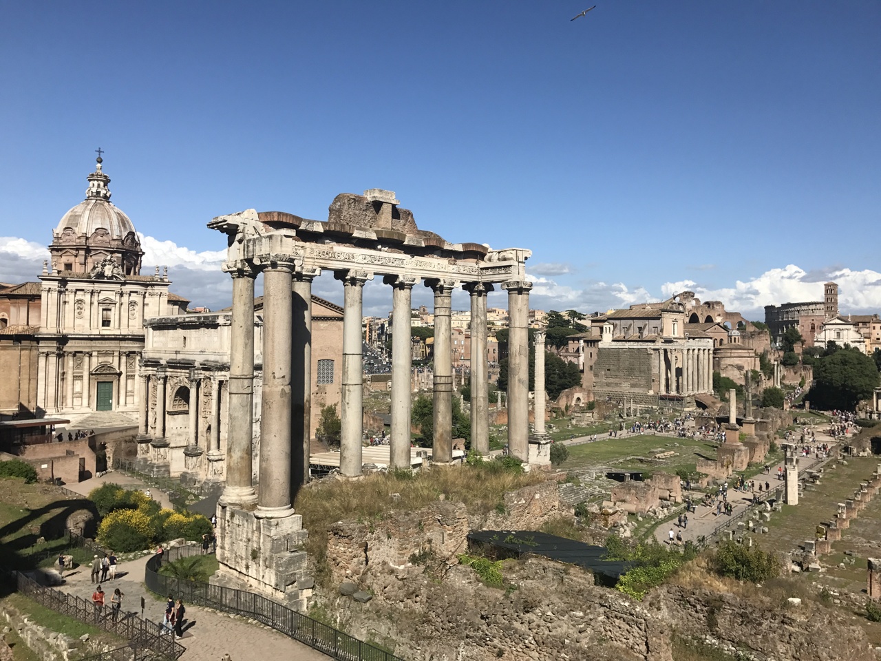 Columnas del Templo de Saturno en el Foro Romano con cúpulas de iglesias al fondo