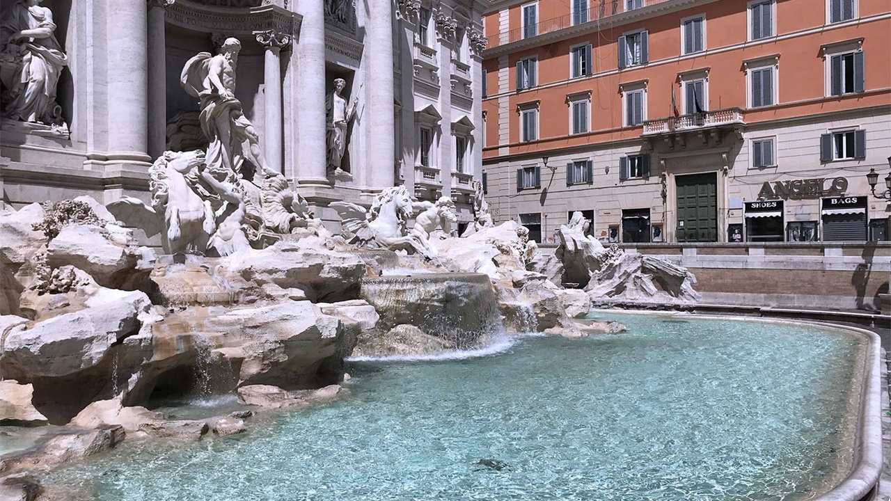 Das Bild zeigt den Trevi-Brunnen mit seinen kunstvollen Skulpturen und dem klaren Wasser.